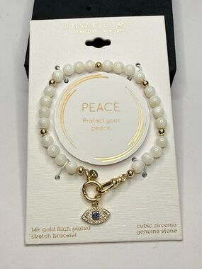 Unwritten White Beaded Bracelet with Gold Accents and Blue Centered Eye Charm